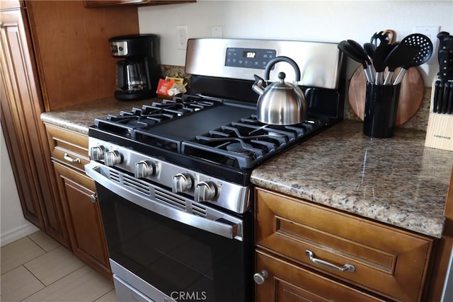 kitchen with gas range and dark stone countertops