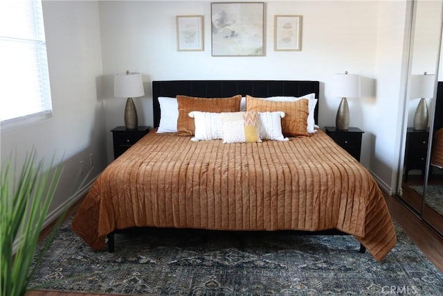 bedroom featuring dark wood-style floors and baseboards