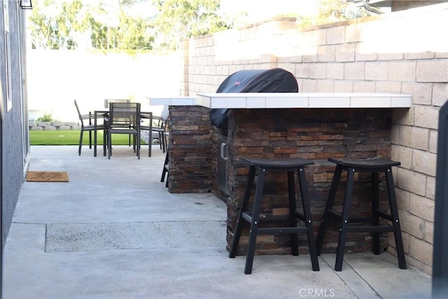 view of patio / terrace featuring fence, outdoor dry bar, and outdoor dining space