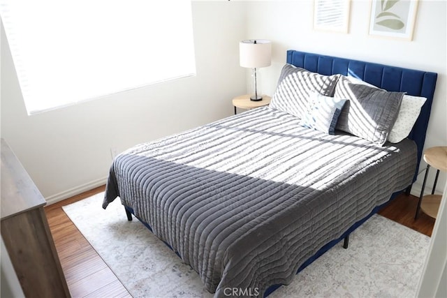 bedroom featuring baseboards and wood finished floors