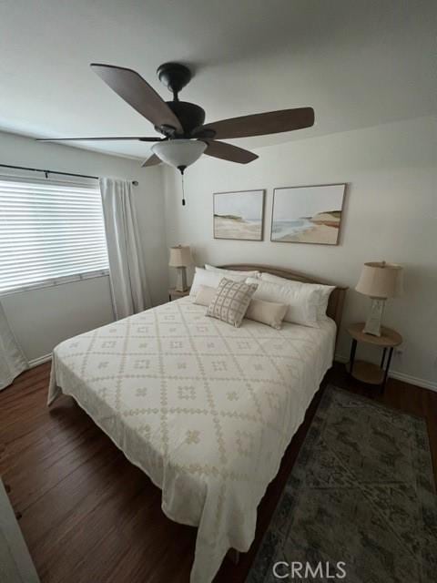 bedroom featuring dark wood-style flooring, ceiling fan, and baseboards