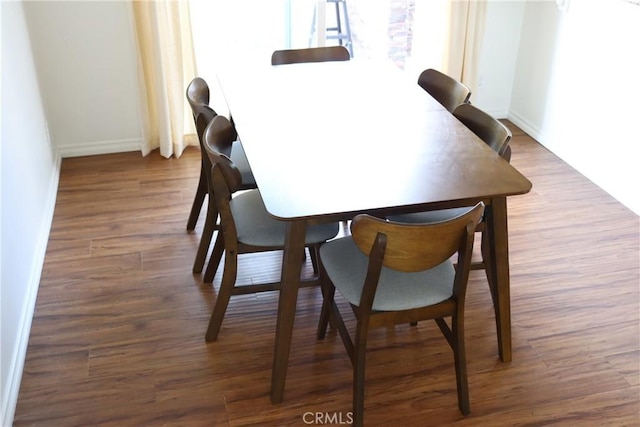 dining room featuring dark wood-style floors and baseboards