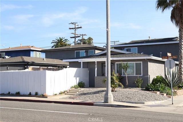 view of front of property with fence and stucco siding