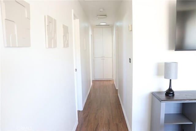 hall with dark wood-style floors and baseboards