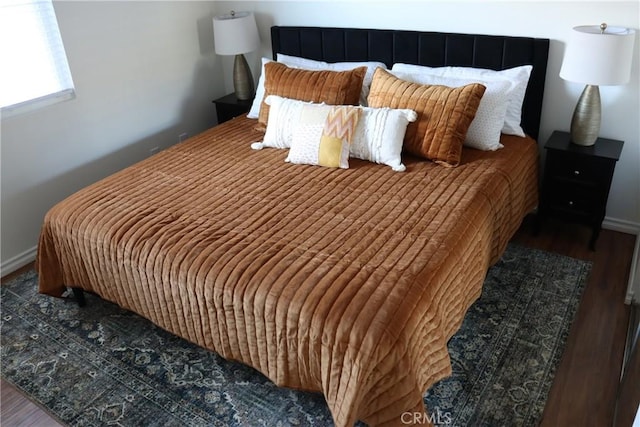 bedroom featuring wood finished floors and baseboards