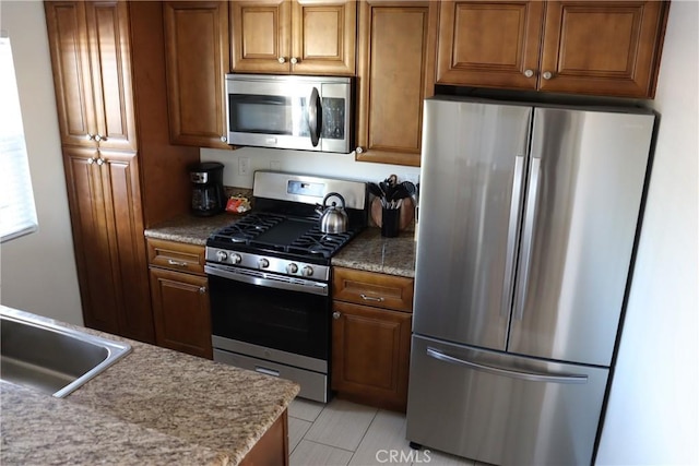 kitchen featuring stainless steel appliances and brown cabinetry