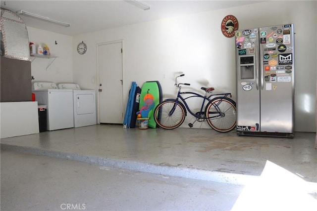 garage with washer and dryer and stainless steel refrigerator with ice dispenser