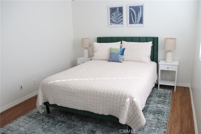 bedroom with baseboards and wood finished floors