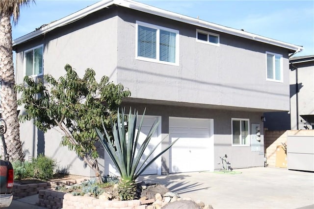 view of front of home featuring a garage, driveway, and stucco siding