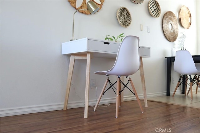 home office with baseboards and dark wood-type flooring