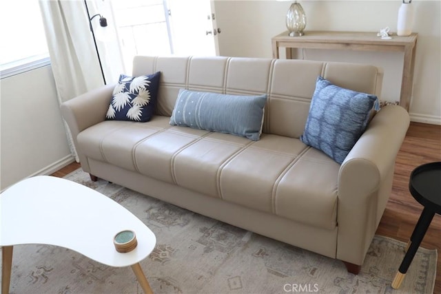 living area with light wood-style floors, plenty of natural light, and baseboards