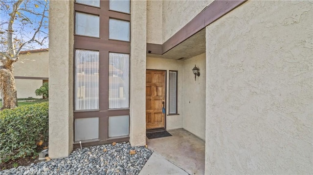 doorway to property featuring stucco siding