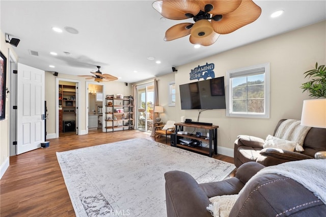 living room featuring ceiling fan, baseboards, wood finished floors, and recessed lighting