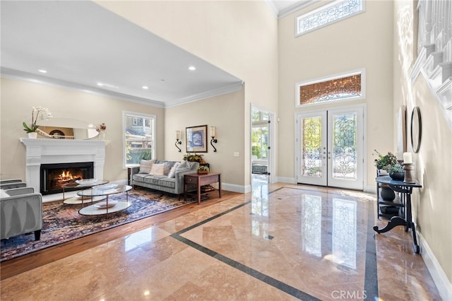 foyer featuring crown molding, plenty of natural light, and baseboards