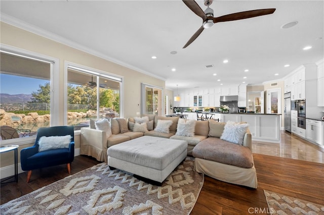 living area with recessed lighting, light wood-type flooring, and crown molding