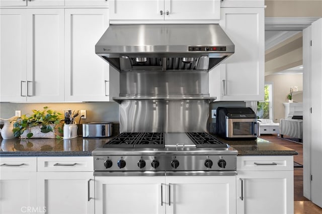 kitchen featuring stainless steel gas stovetop, white cabinetry, and extractor fan