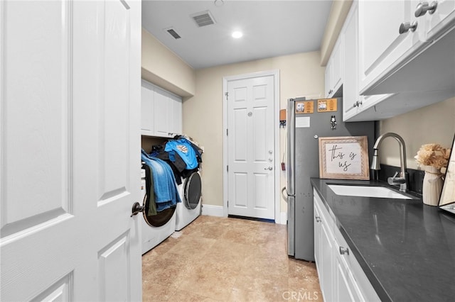 laundry area featuring visible vents, a sink, cabinet space, and washer and dryer