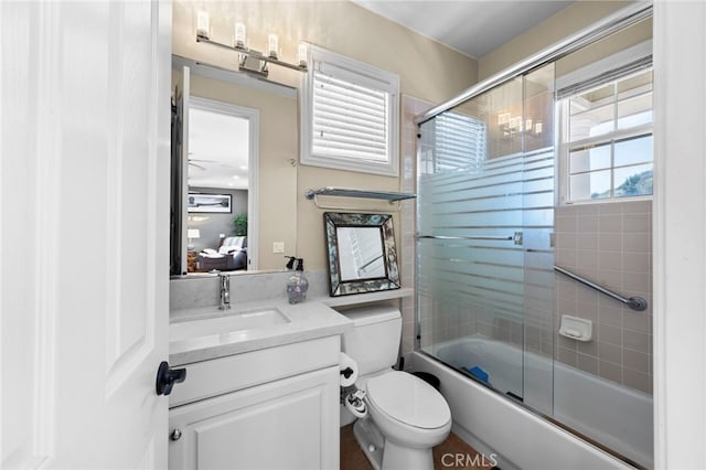 full bath with enclosed tub / shower combo, vanity, and toilet