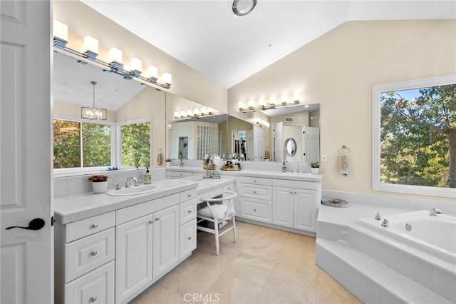 bathroom with lofted ceiling, a garden tub, vanity, and tile patterned floors