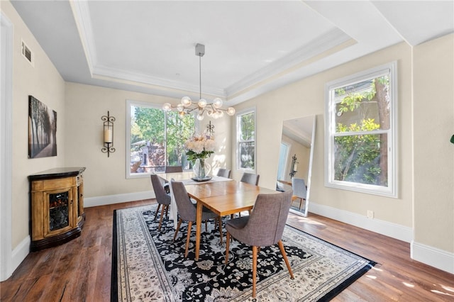 dining space with visible vents, a tray ceiling, dark wood finished floors, and baseboards