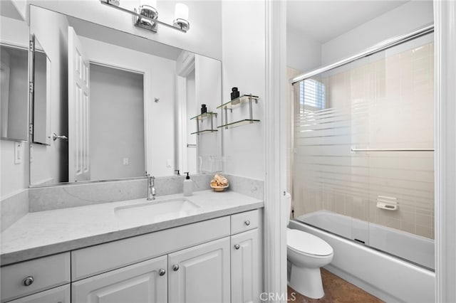 bathroom featuring bath / shower combo with glass door, vanity, and toilet