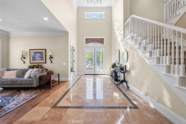 entrance foyer with ornamental molding, plenty of natural light, stairway, and baseboards