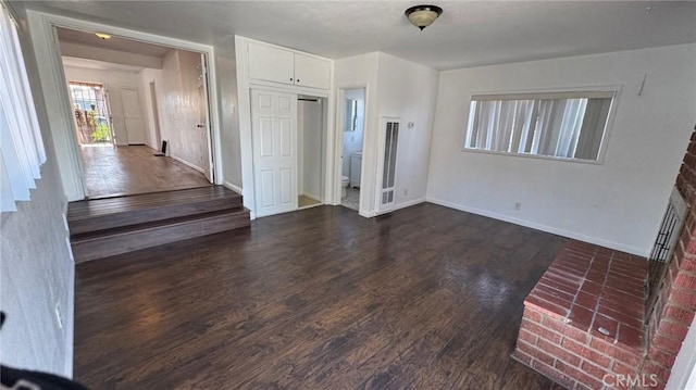 foyer with dark wood-style floors and baseboards