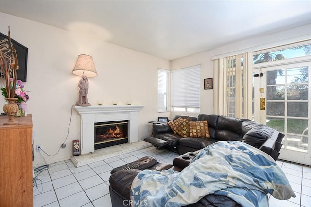 living area with light tile patterned floors and a glass covered fireplace