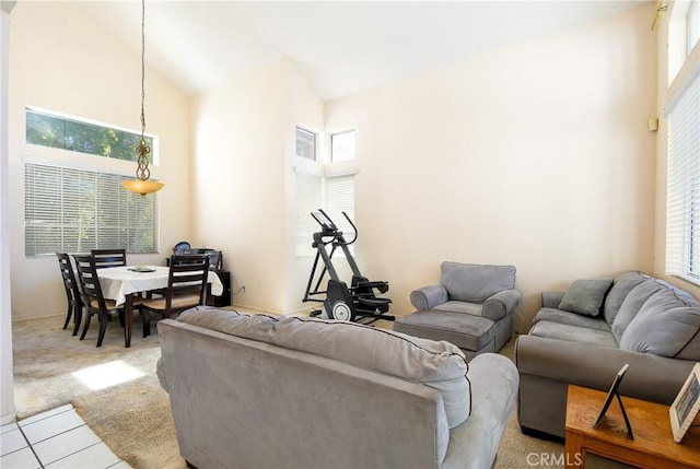 living area featuring high vaulted ceiling and light colored carpet