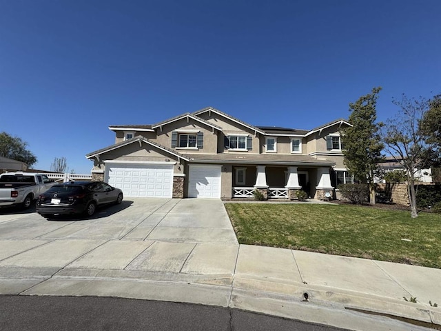 view of front of home featuring covered porch, solar panels, a garage, concrete driveway, and a front yard