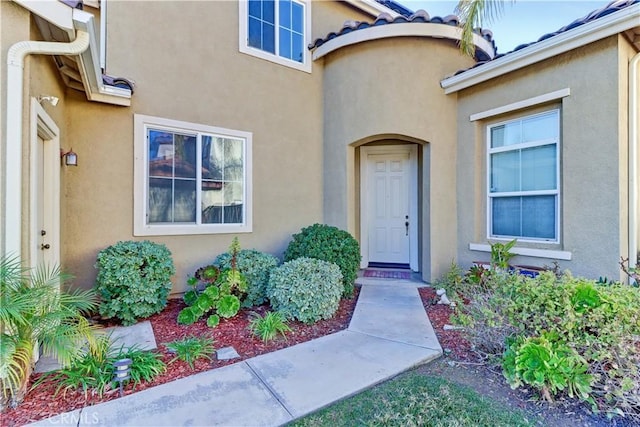 entrance to property featuring stucco siding