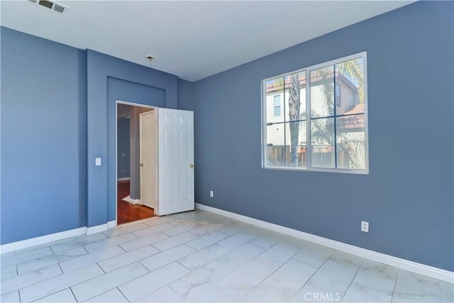 unfurnished bedroom with marble finish floor, baseboards, and visible vents