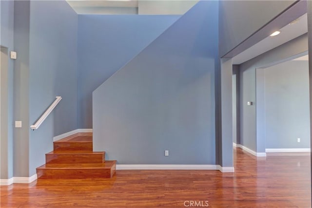 staircase with baseboards and wood finished floors