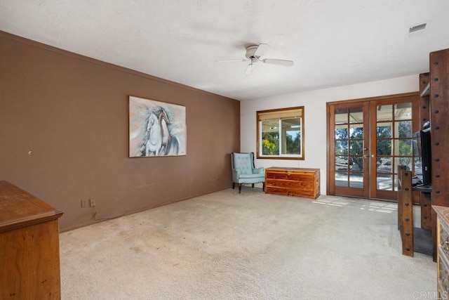 unfurnished room featuring visible vents, light colored carpet, a ceiling fan, and french doors