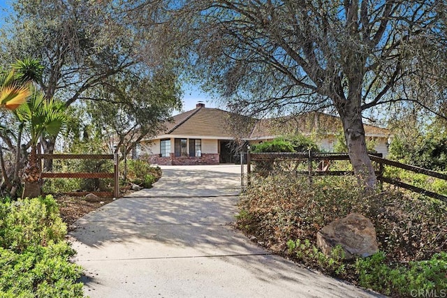 single story home with driveway and a fenced front yard