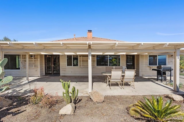 back of house with a patio, a chimney, and a pergola