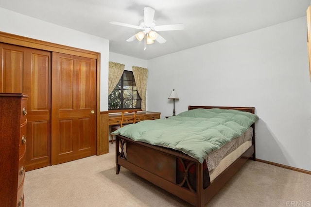 bedroom featuring light carpet, a ceiling fan, and baseboards