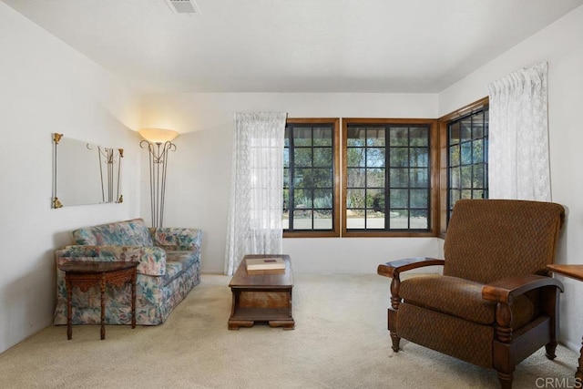 sitting room featuring visible vents and light colored carpet