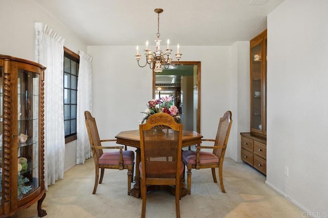 dining room with a chandelier and light colored carpet