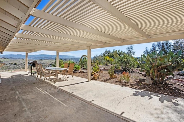 view of patio featuring a mountain view, a pergola, and outdoor dining space