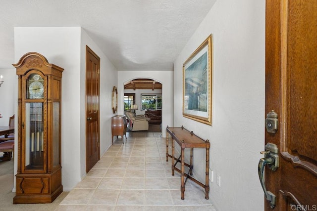 interior space with arched walkways and light tile patterned flooring