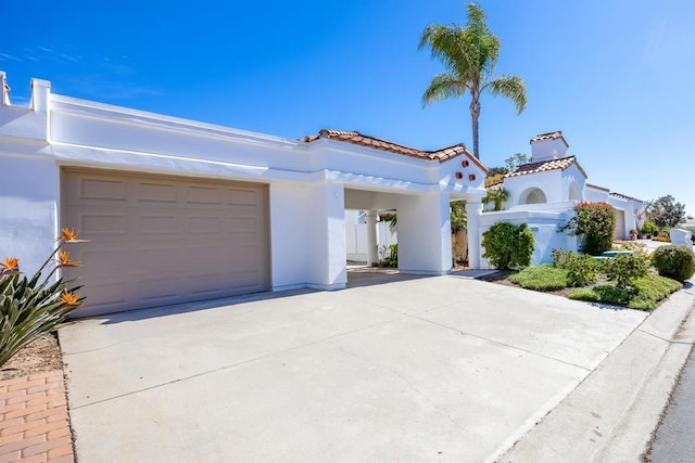 mediterranean / spanish-style home featuring driveway, a tile roof, and stucco siding