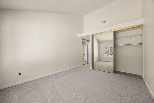 unfurnished bedroom with light carpet, a closet, visible vents, and baseboards