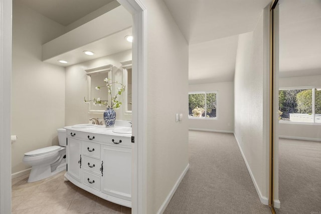 full bathroom featuring a wealth of natural light, a sink, baseboards, and double vanity