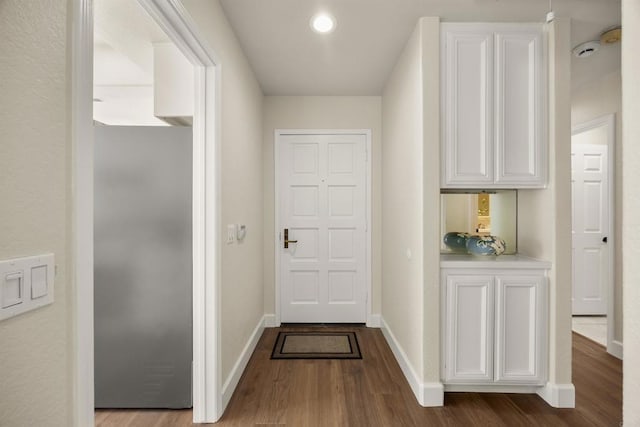 doorway with recessed lighting, wood finished floors, and baseboards