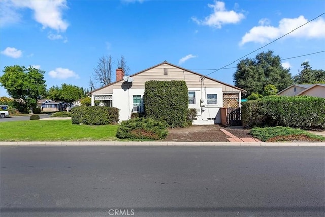 view of front of house with a chimney and a front lawn