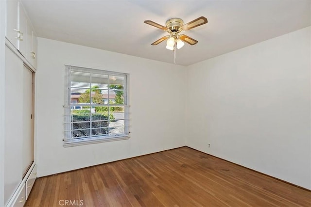 empty room with a ceiling fan and wood finished floors