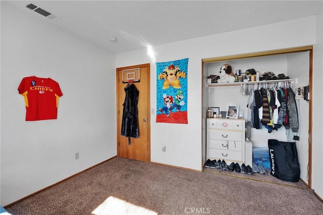 bedroom with baseboards, visible vents, carpet, a textured ceiling, and a closet