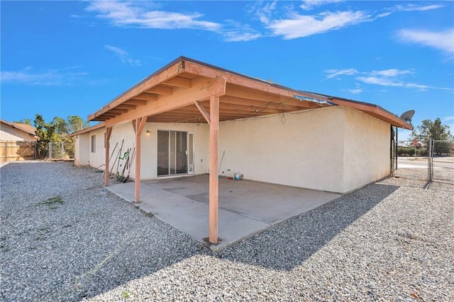 exterior space with a carport, fence, a patio, and stucco siding