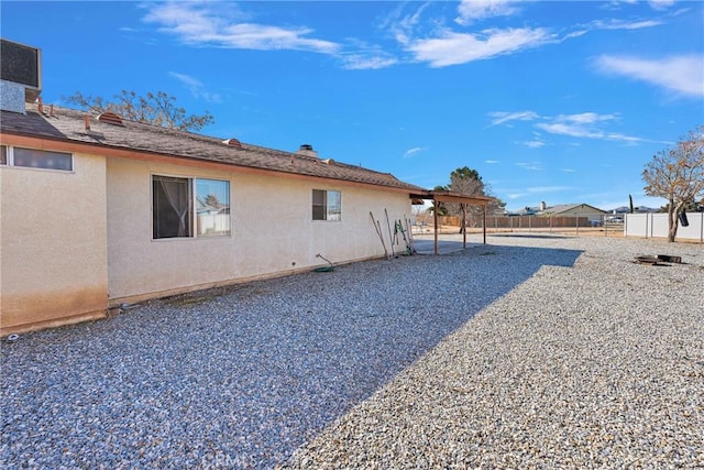 exterior space with a patio area, fence, and stucco siding